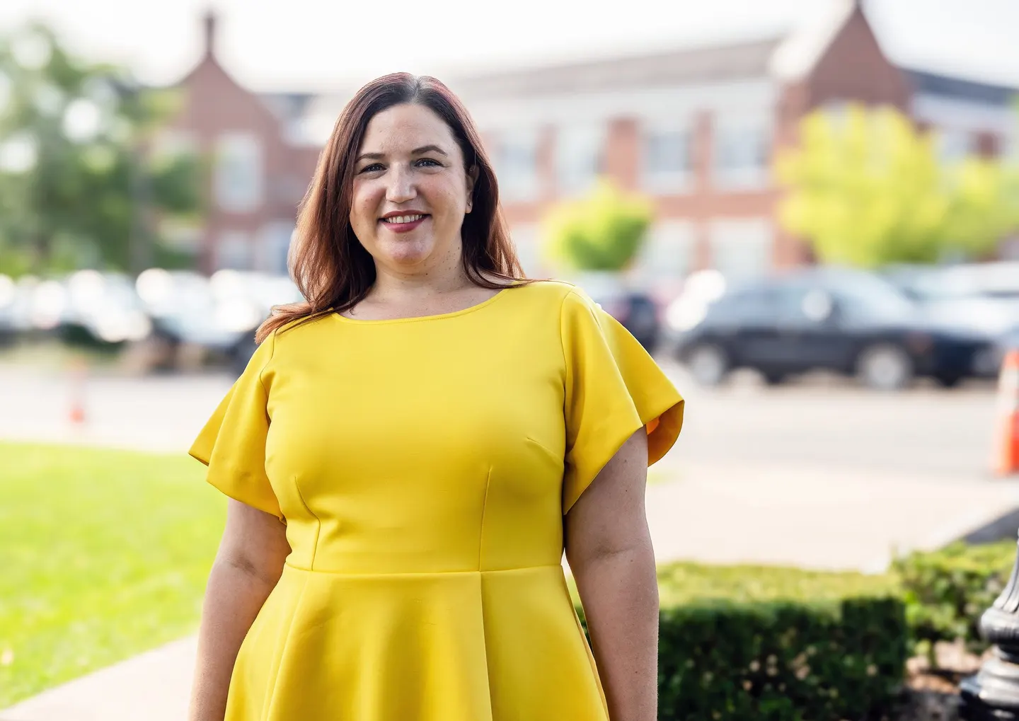 Jen Lunsford smiling outdoors in a yellow dress