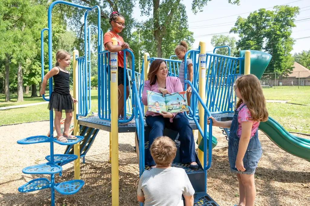 Jen Lunsford reading with children at a neighborhood playground