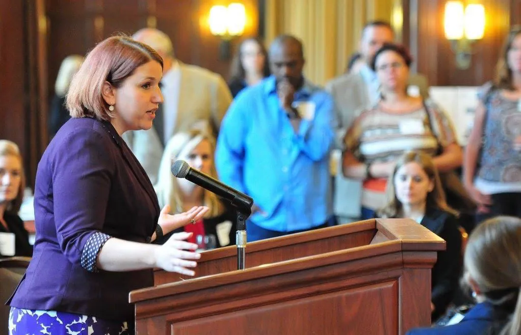 Jen Lunsford speaking at a podium before an audience