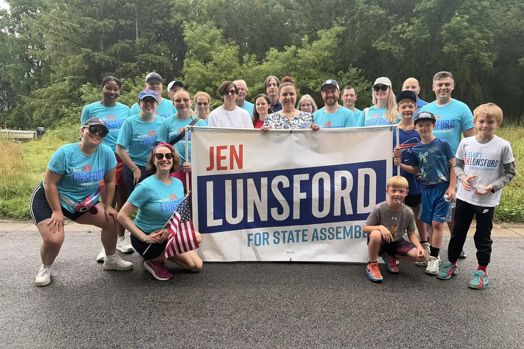 Volunteers and supporters holding a Jen Lunsford for State Assembly banner